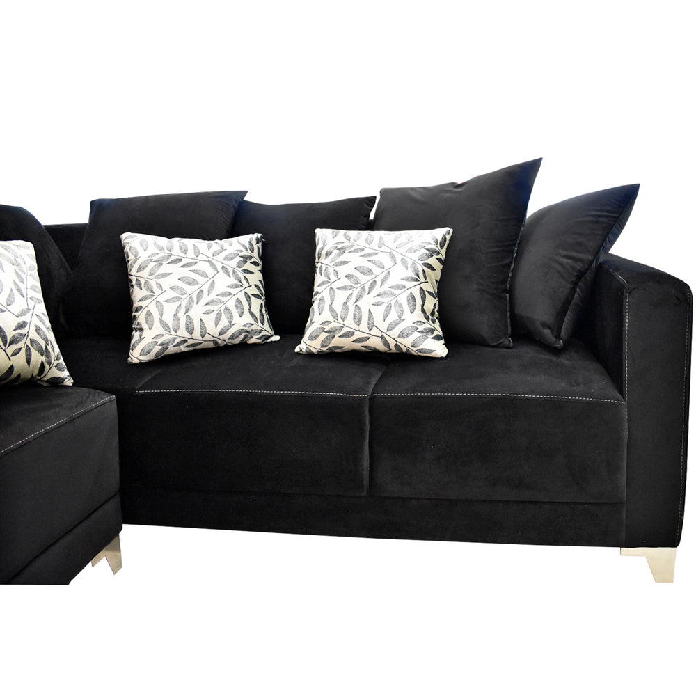 Sofá esquinero color negro con cojines decorativos estampados y patas doradas.