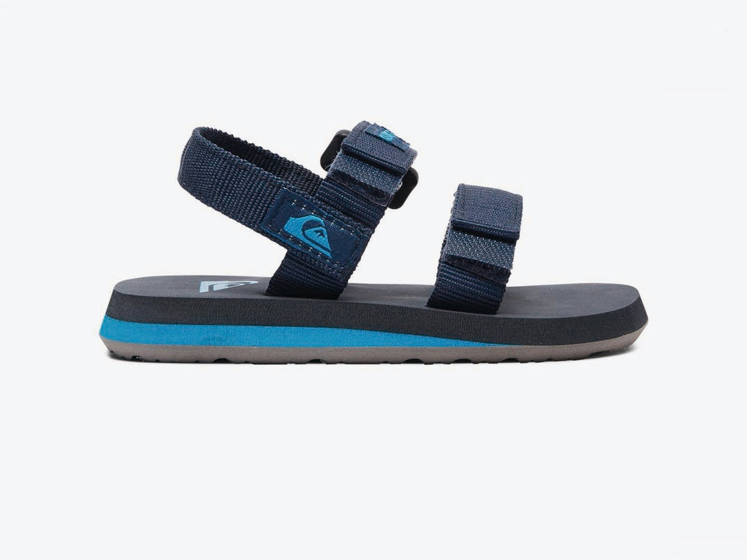 Sandalia infantil Quiksilver color azul marino con suela celeste y correas de velcro.