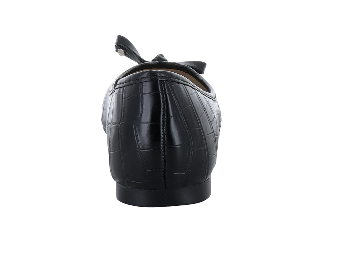Zapato plano negro con textura de cocodrilo y detalle de moño decorativo en la punta.
