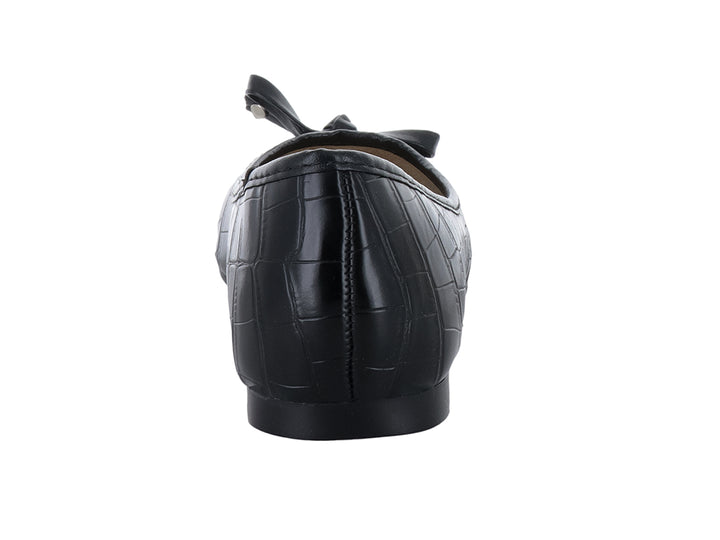 Zapato plano negro con textura de cocodrilo y detalle de moño decorativo en la punta.