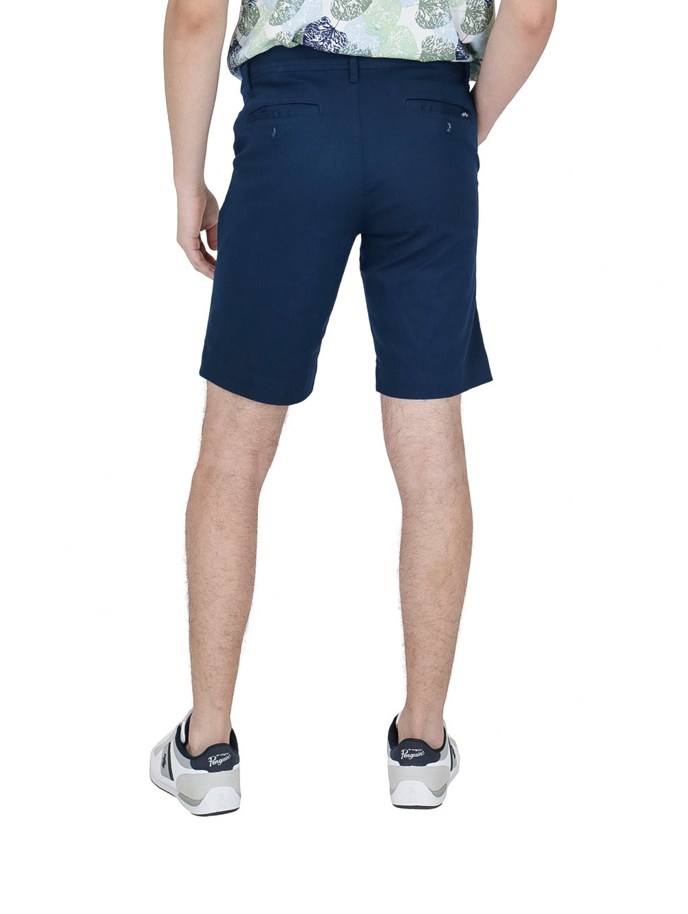 Hombre vistiendo bermudas color azul acero de la marca White Peak con tenis blancos.