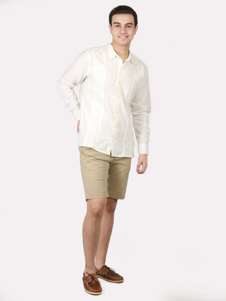 Hombre vistiendo bermudas color khaki, camisa blanca y zapatos cafés.