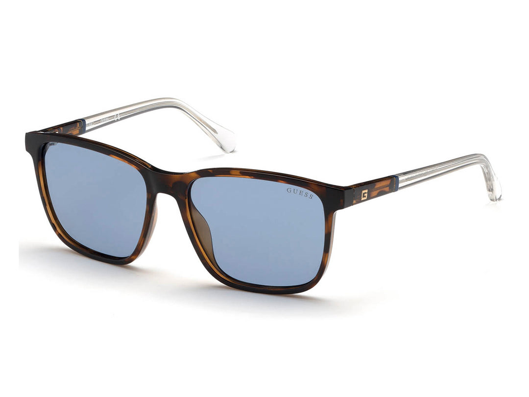 Lentes de sol Guess con armazón color carey, micas azules y varillas transparentes.