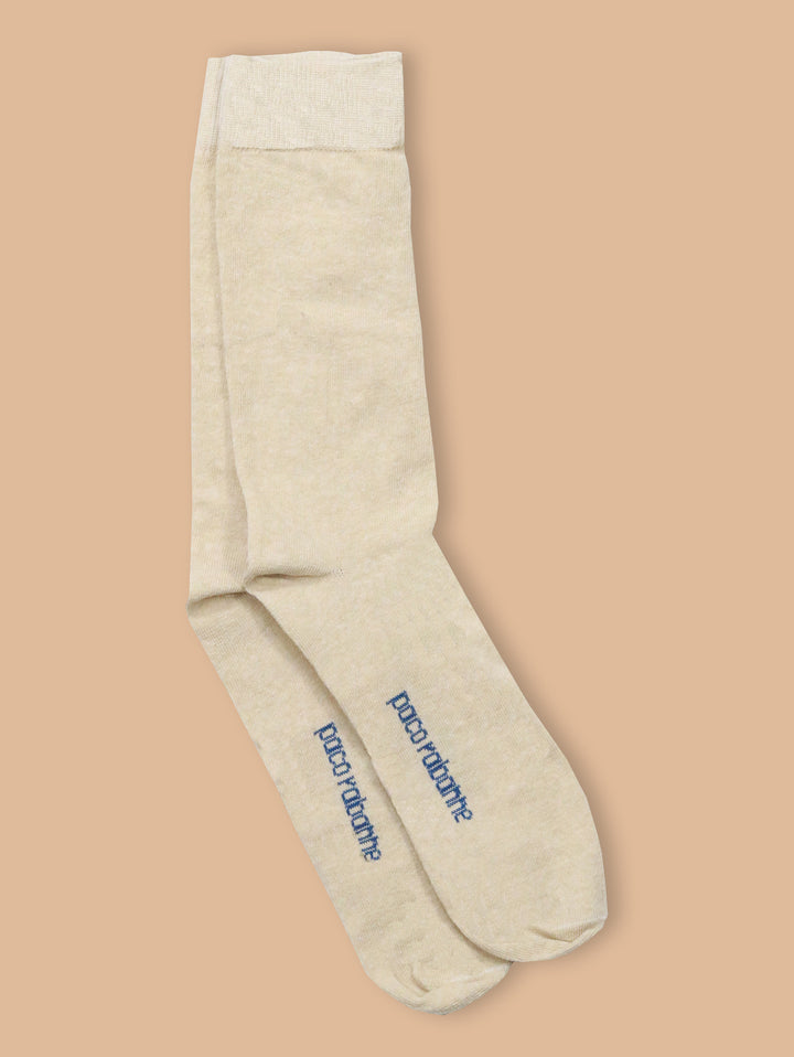 Par de calcetines color beige de la marca Paco Rabanne con texto azul en la planta.