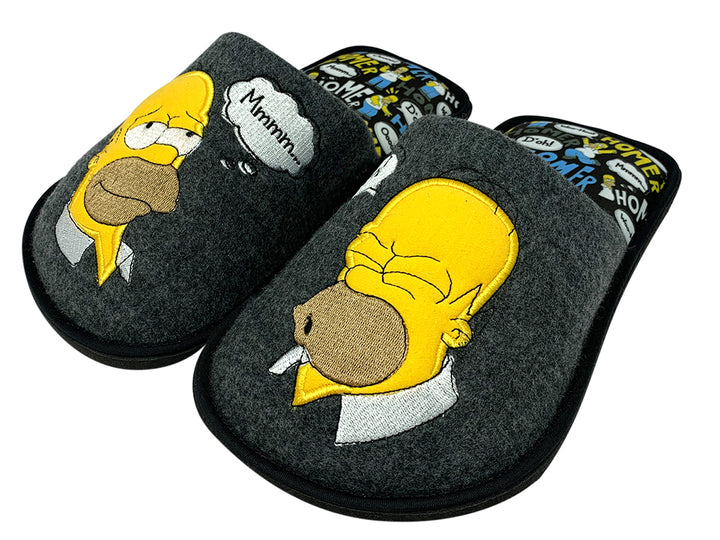 Par de pantuflas grises con el rostro de Homer Simpson bordado en amarillo y suela negra.