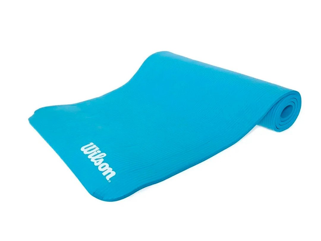 Tapete de yoga color azul marca Wilson, parcialmente enrollado sobre fondo blanco.