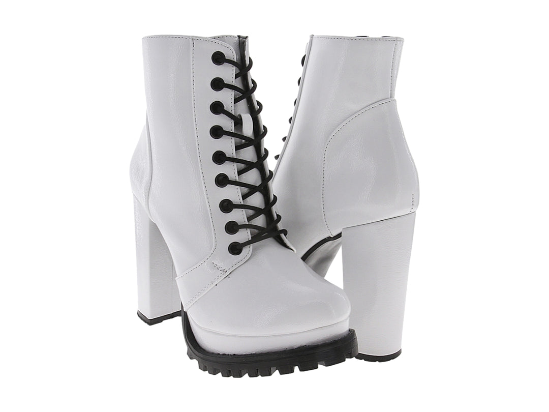 Bota blanca de charol con tacón grueso, cordones negros y suela track negra.