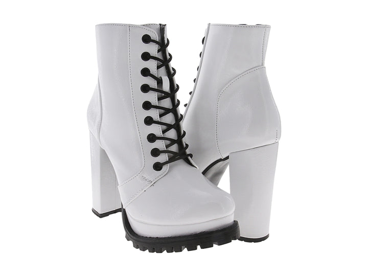 Bota blanca de charol con tacón grueso, cordones negros y suela track negra.