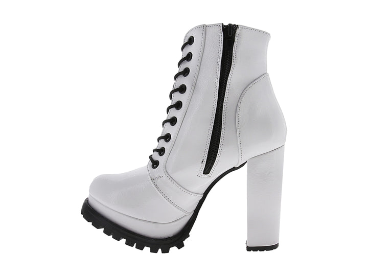 Bota blanca de charol con tacón grueso, cordones negros y suela track negra.