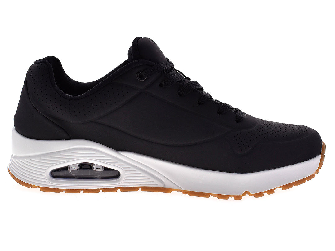 Tenis deportivos Skechers para hombre en color negro con suela blanca y beige.