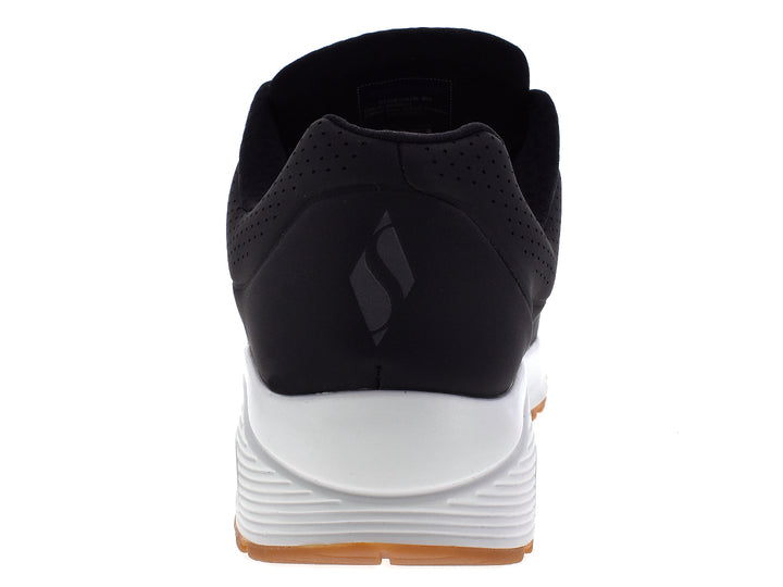 Tenis deportivos Skechers para hombre en color negro con suela blanca y beige.