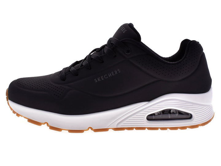 Tenis deportivos Skechers para hombre en color negro con suela blanca y beige.