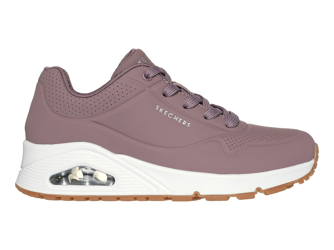 Tenis Skechers color malva con suela blanca y amortiguación visible, vista lateral.