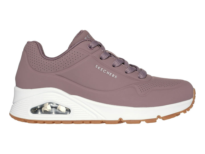 Tenis Skechers color malva con suela blanca y amortiguación visible, vista lateral.