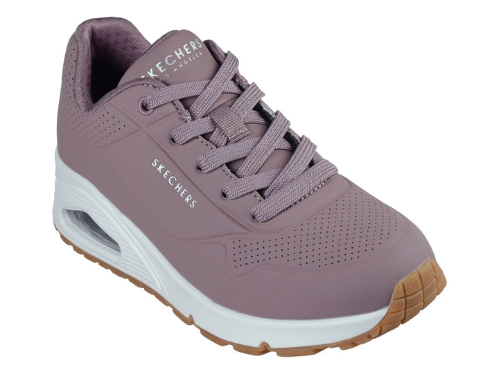 Tenis Skechers color malva con suela blanca y amortiguación visible, vista lateral.