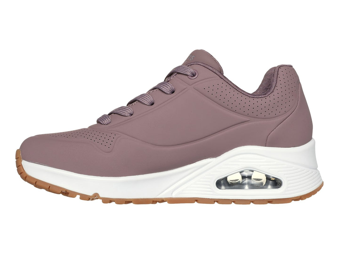 Tenis Skechers color malva con suela blanca y amortiguación visible, vista lateral.