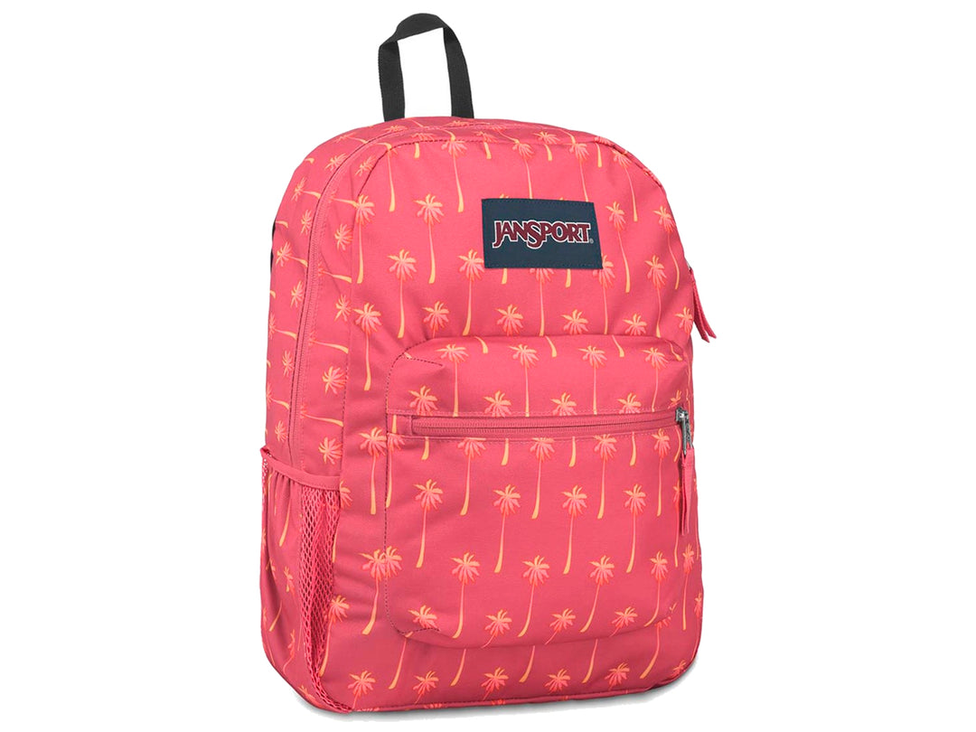 Mochila JanSport rosa con estampado de palmeras amarillas y un termo morado en el bolsillo lateral.