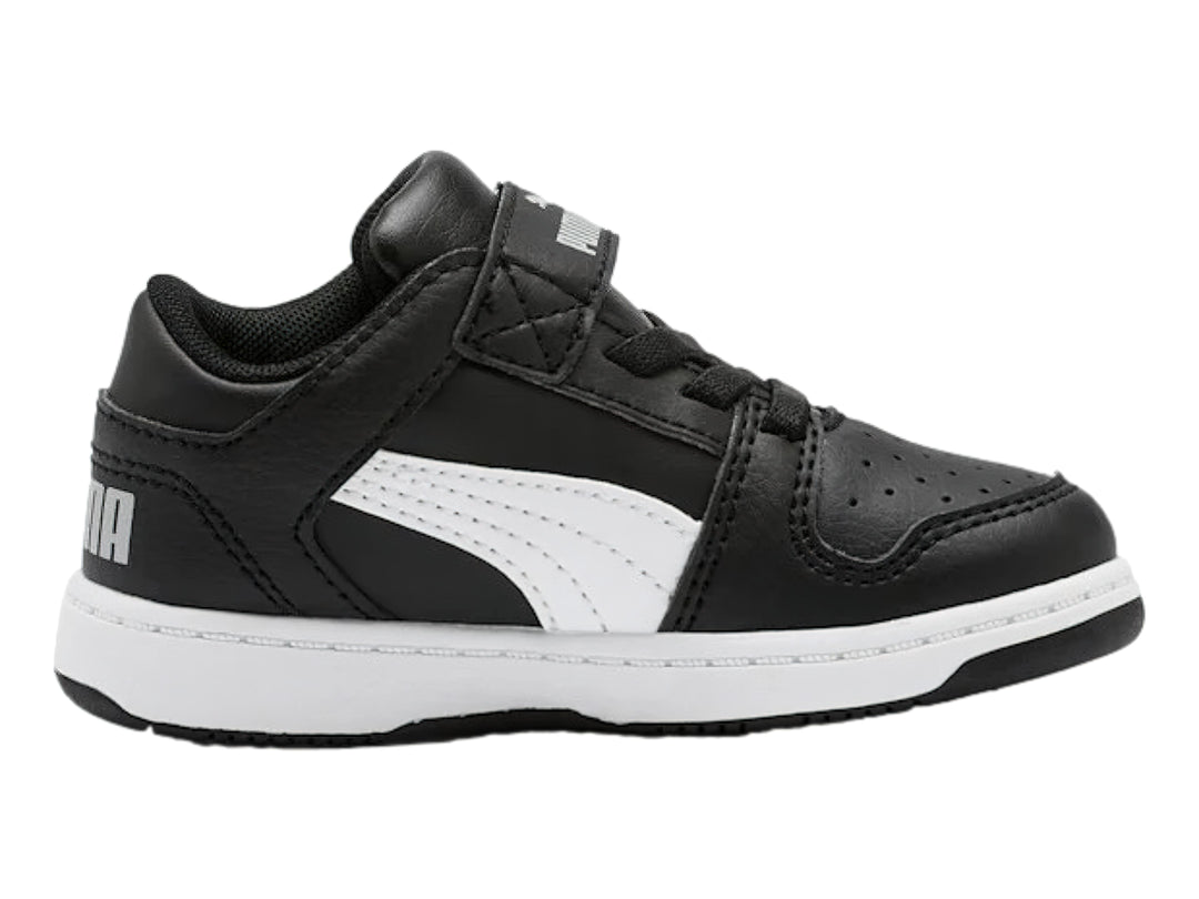 Tenis PUMA infantiles color negro con suela y franja lateral blanca, cierre de velcro.