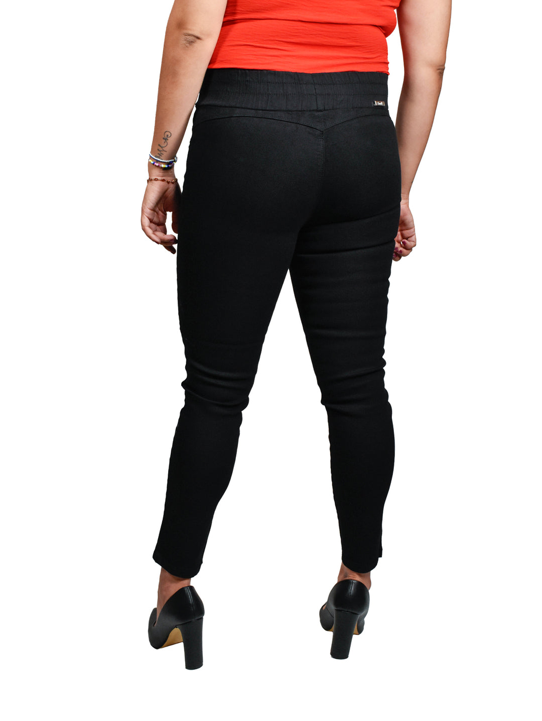 Mujer usando pantalones jogger negros con cintura elástica y zapatos de tacón.