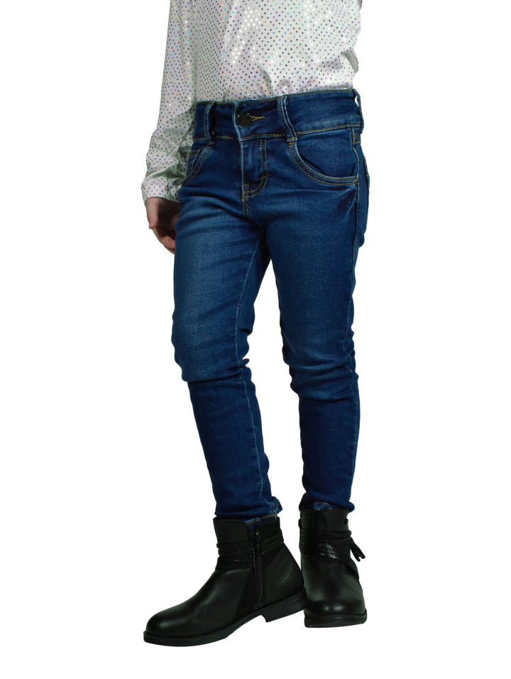 Jeans de mezclilla azul ajustados para niña combinados con botas negras.