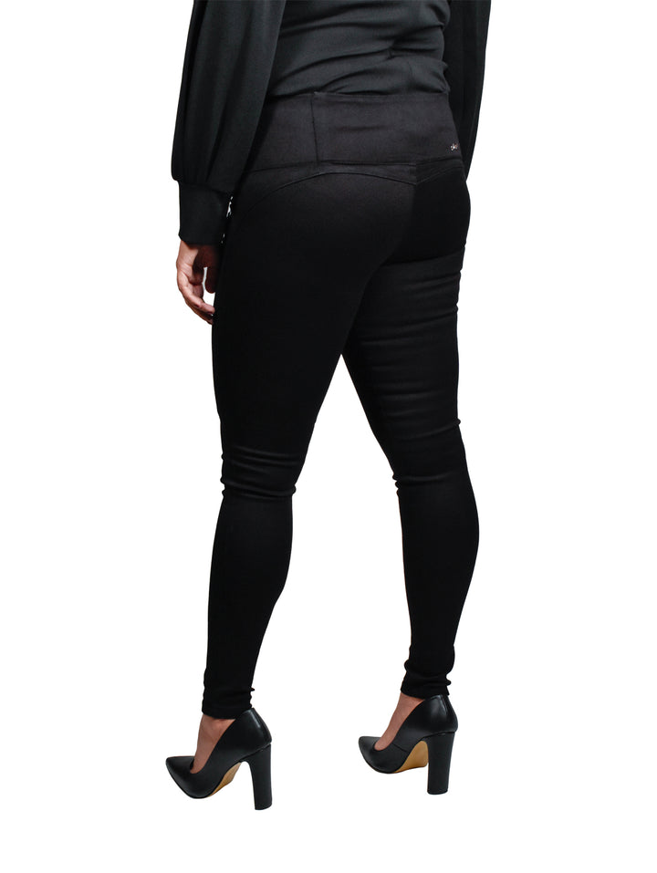Mujer vistiendo leggings de mezclilla stretch color negro y zapatos de tacón.