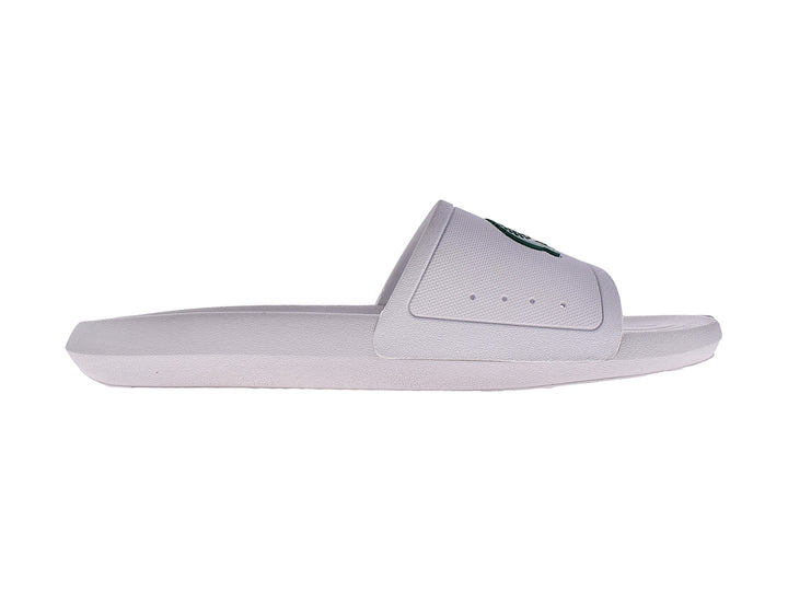 Sandalia slide blanca de la marca Lacoste con logo verde en la banda superior.