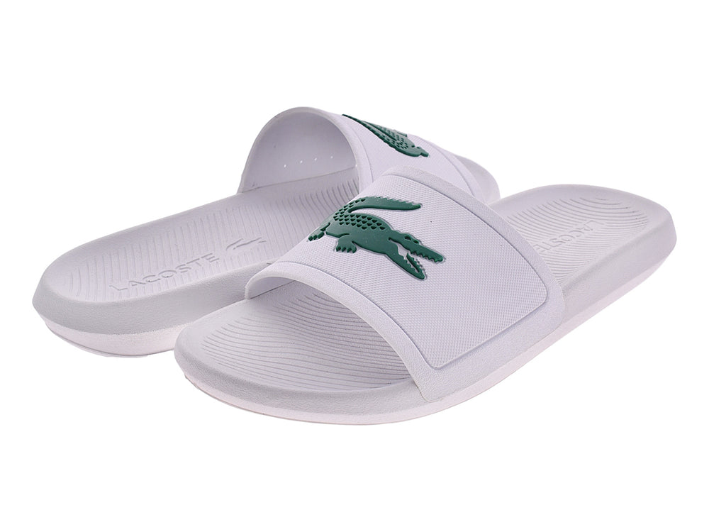 Sandalia slide blanca de la marca Lacoste con logo verde en la banda superior.