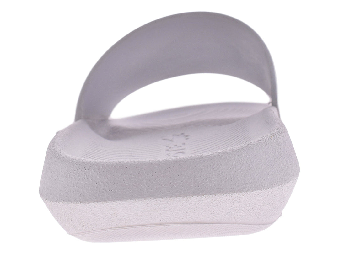 Sandalia slide blanca de la marca Lacoste con logo verde en la banda superior.