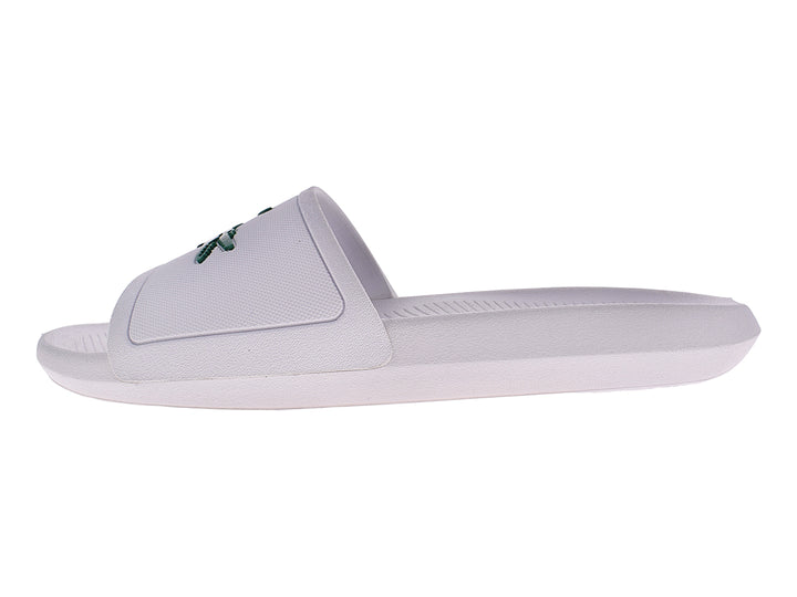 Sandalia slide blanca de la marca Lacoste con logo verde en la banda superior.