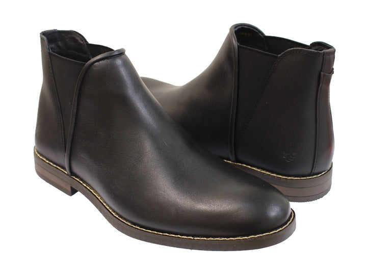 Botas negras para hombre de cuero con costuras claras en la suela sobre fondo blanco.
