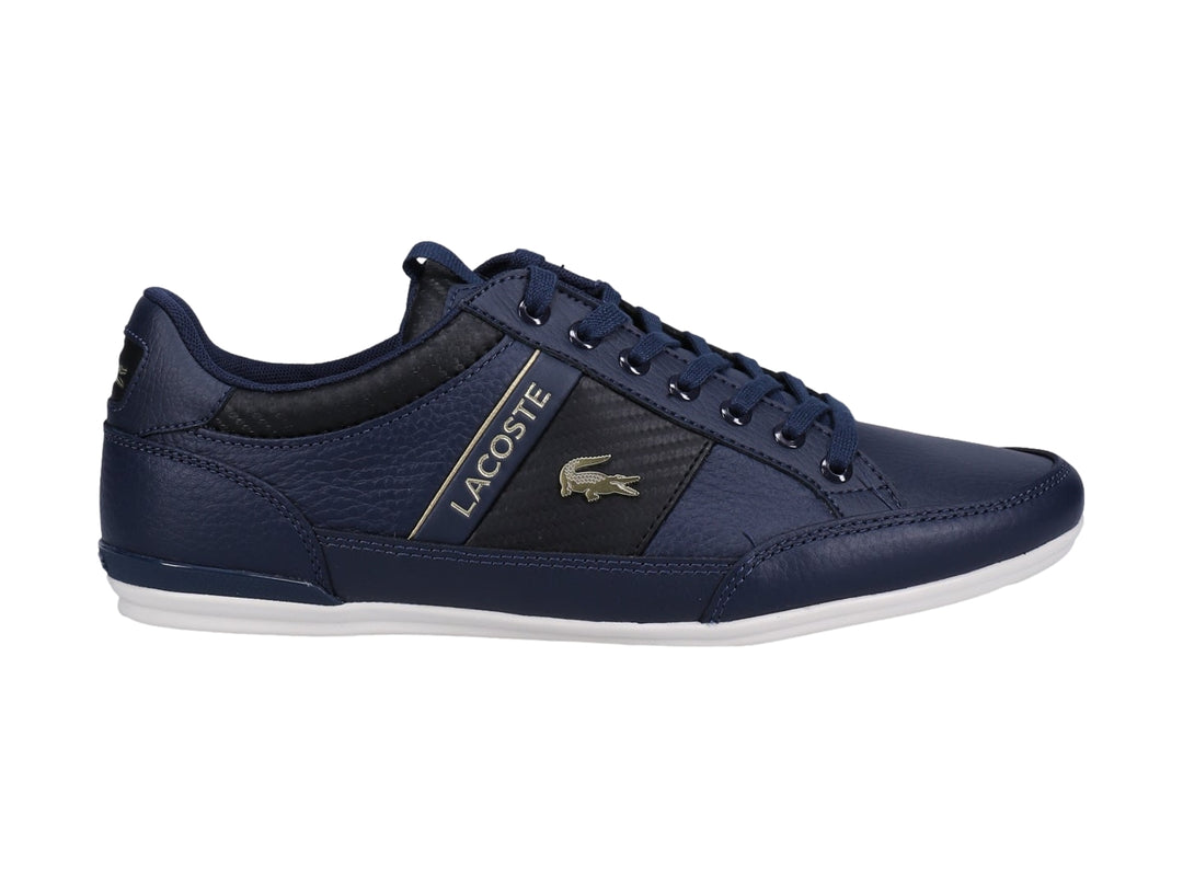 Tenis Lacoste color azul marino y negro con suela blanca y detalles dorados.