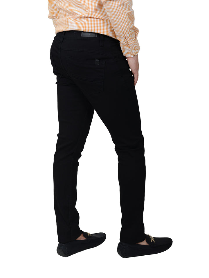 Hombre vistiendo jeans negros slim fit con camisa a cuadros y mocasines negros.
