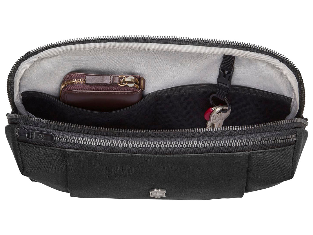 Cangurera color negro de la marca Victorinox con logotipo metálico central y cierre superior.
