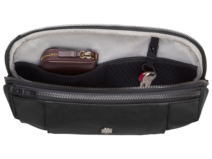 Cangurera color negro de la marca Victorinox con logotipo metálico central y cierre superior.