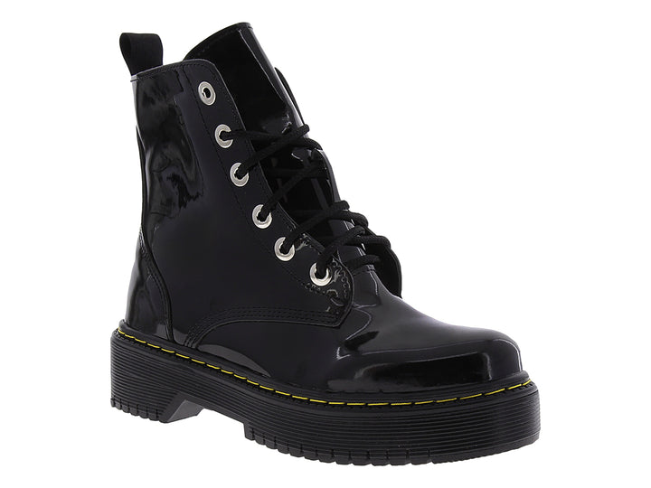Bota de combate negra brillante con suela track y costuras amarillas.
