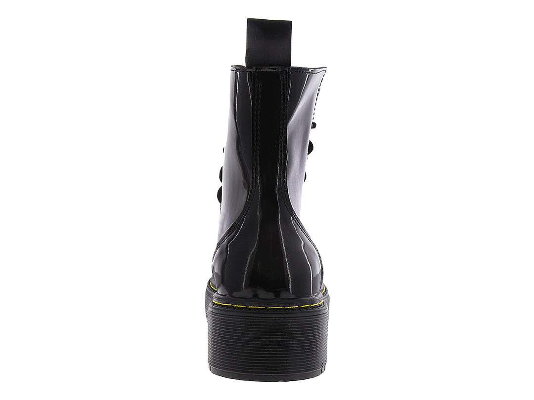 Bota de combate negra brillante con suela track y costuras amarillas.