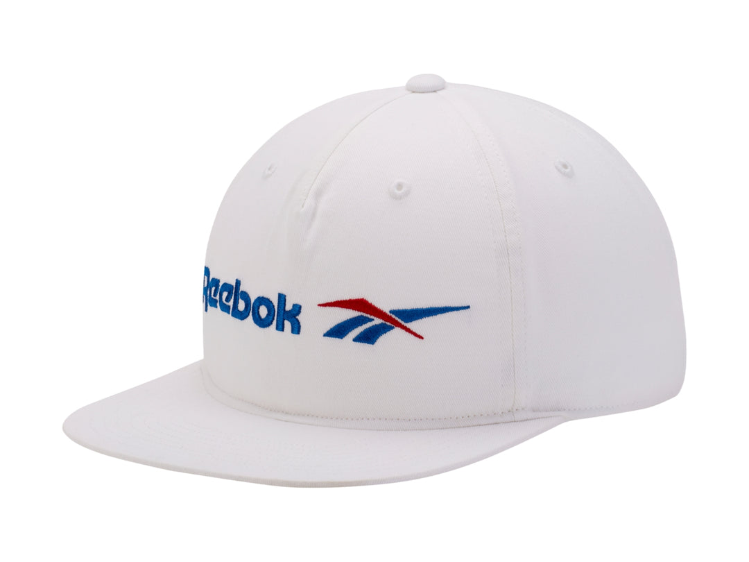 Gorra Reebok de color blanco con visera plana y logotipo en azul y rojo.