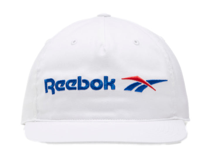 Gorra Reebok de color blanco con visera plana y logotipo en azul y rojo.