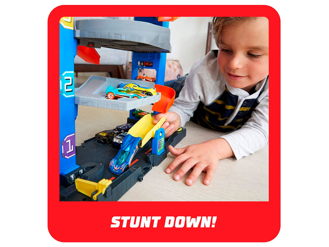 Set de juego Hot Wheels Stunt Garage con pista multinivel, rampas naranjas y un auto incluido en empaque original.