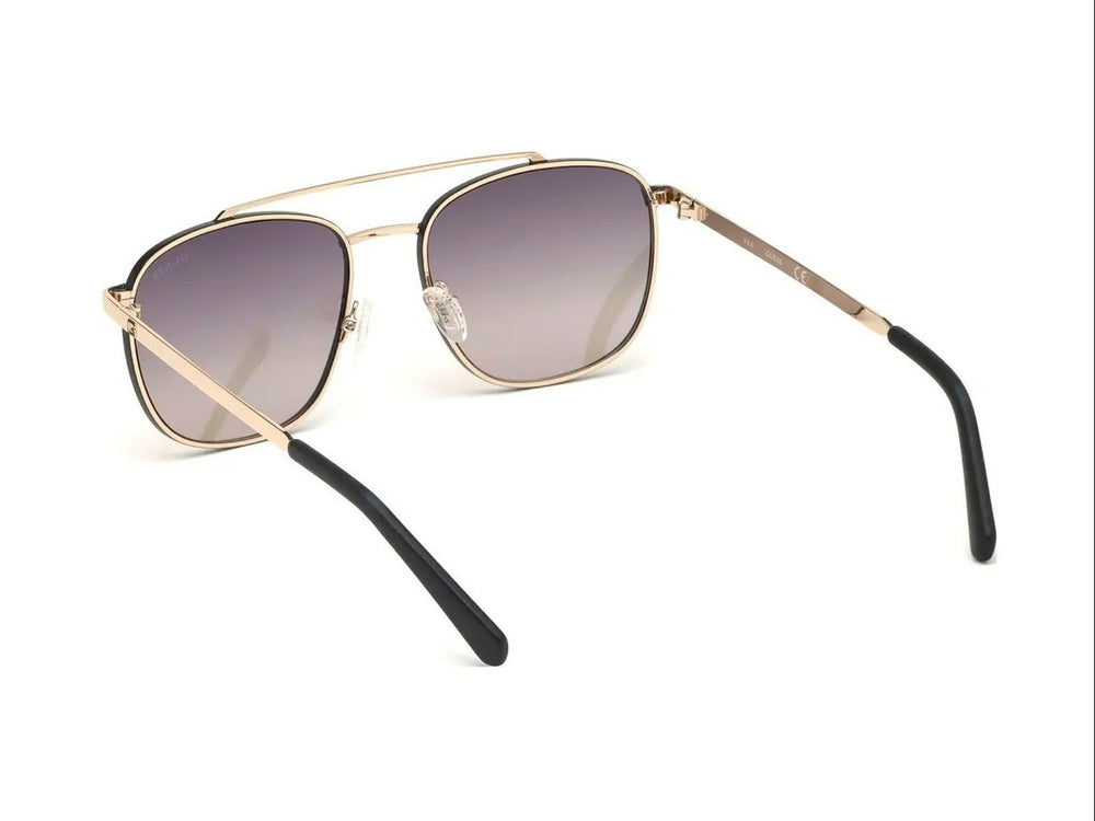 Lentes de sol estilo aviador GUESS con armazón dorado y cristales marrón degradado.