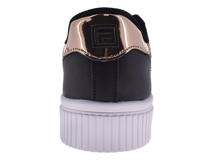 Tenis FILA negros con suela blanca de plataforma y detalle en color oro rosa en el talón.