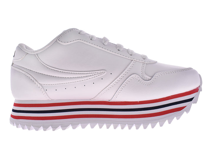 Tenis FILA blancos con detalles de rayas rojas y azules en la suela y base dentada.
