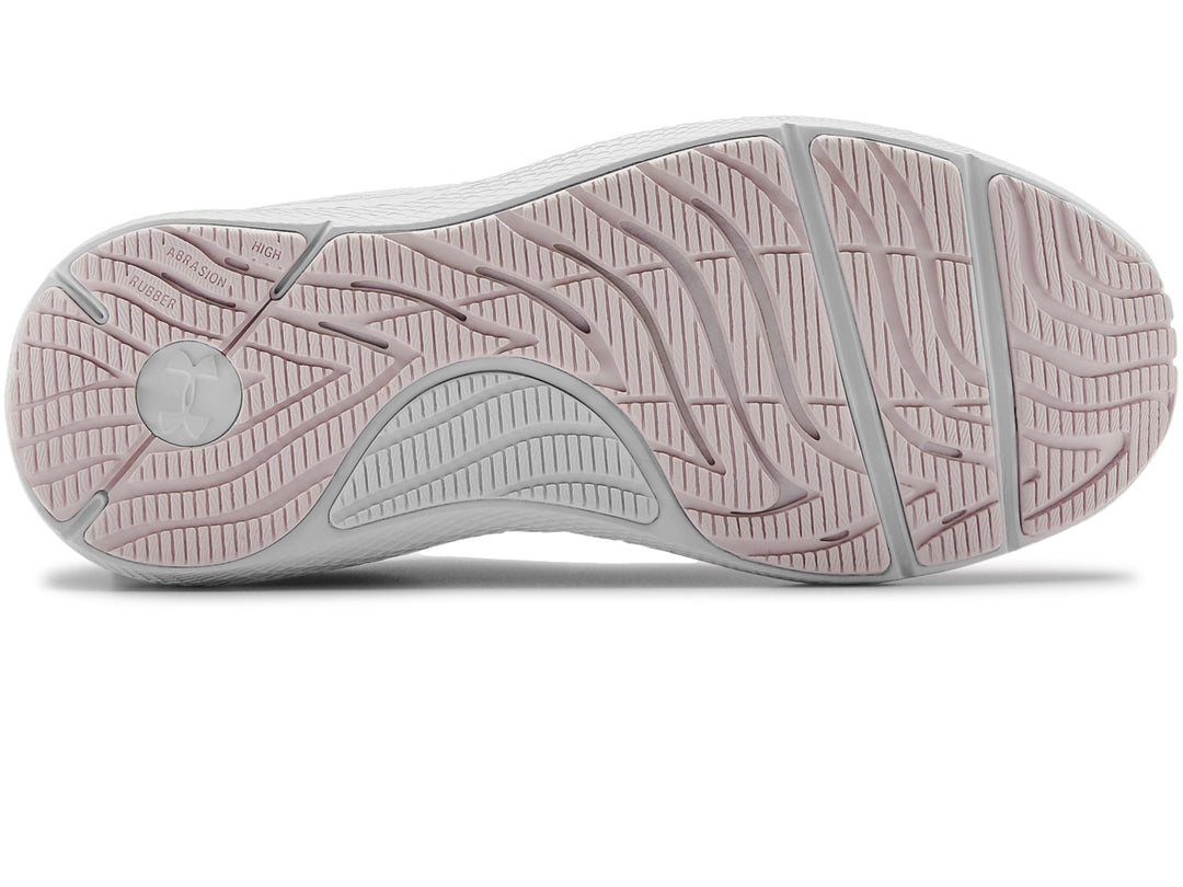 Tenis deportivos Under Armour de color rosa claro con suela blanca.