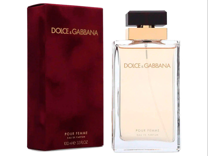 Perfume Dolce &amp; Gabbana Pour Femme con botella de vidrio transparente y caja color guinda.