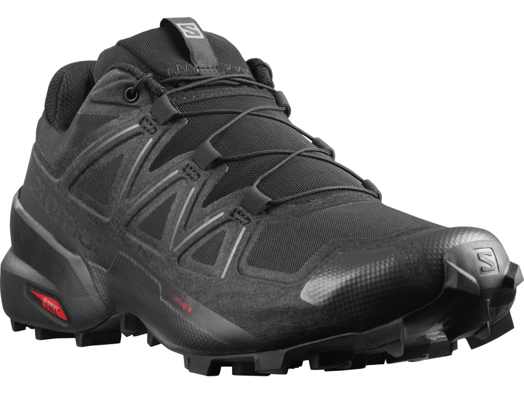 Tenis de trail running Salomon color negro con suela rugosa para hombre.