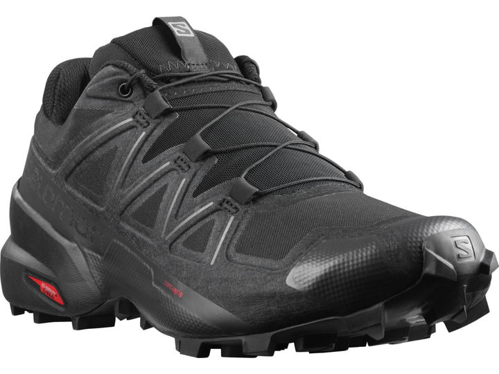 Tenis de trail running Salomon color negro con suela rugosa para hombre.