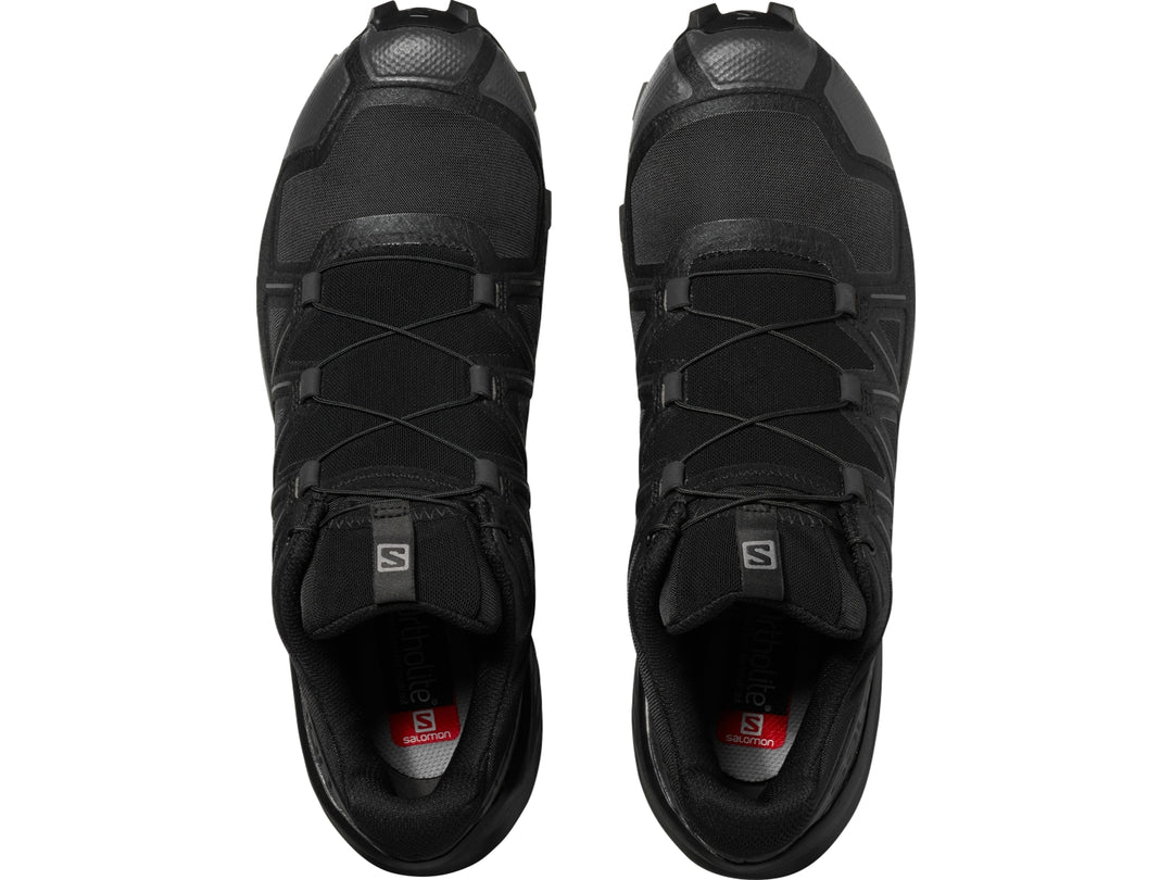 Tenis de trail running Salomon color negro con suela rugosa para hombre.