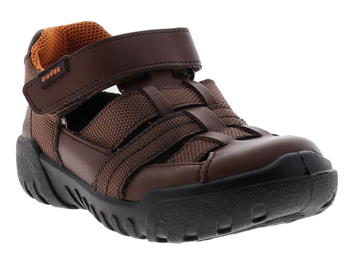Sandalia infantil cerrada color café con suela negra y ajuste de velcro.
