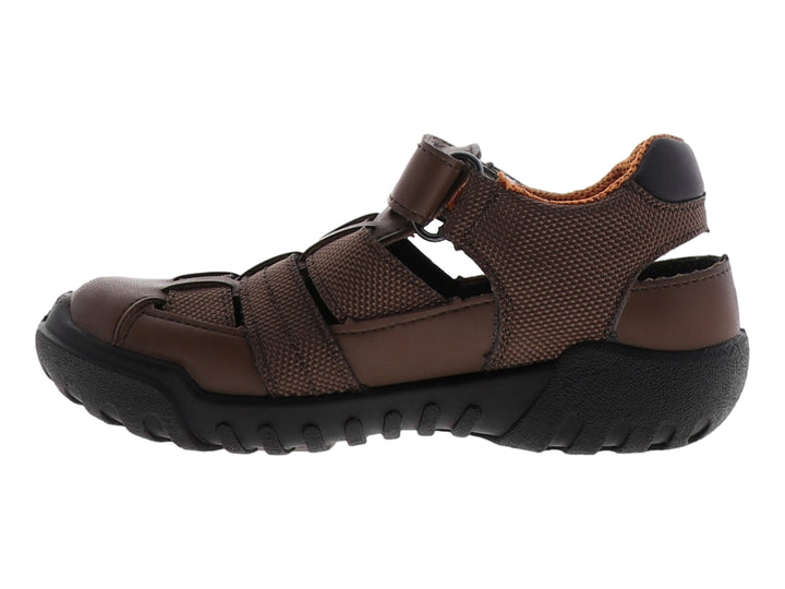 Sandalia infantil cerrada color café con suela negra y ajuste de velcro.