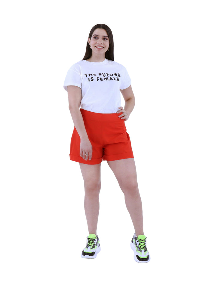Mujer vistiendo short rojo de cintura alta con tenis deportivos sobre fondo blanco.
